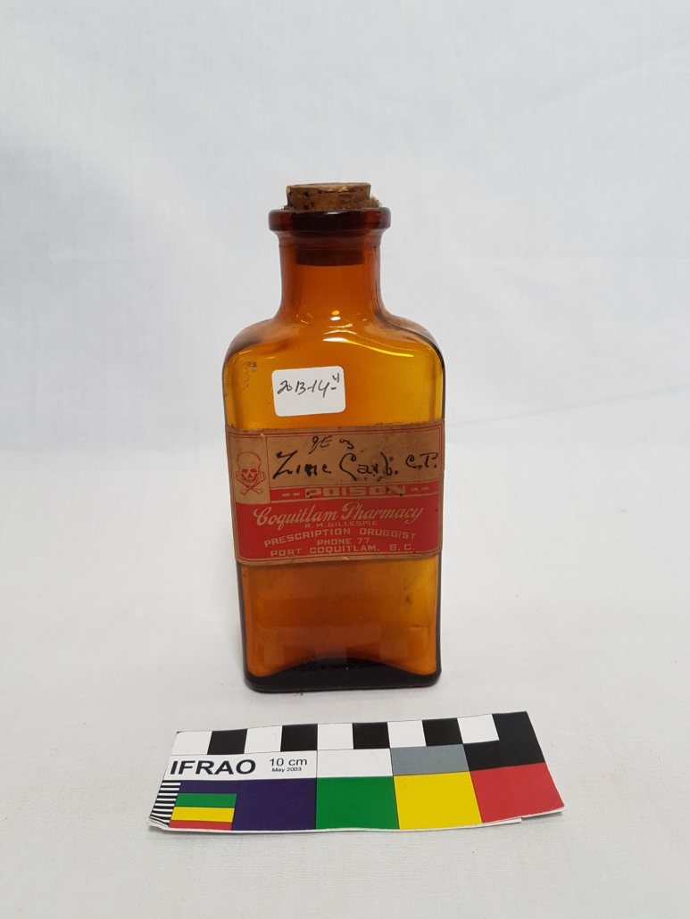 A light brown glass bottle with cork stopper and faded pharmacy label
